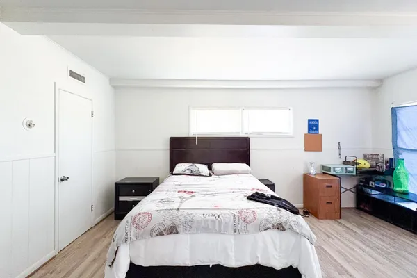 a bedroom with a bed and a potted plant