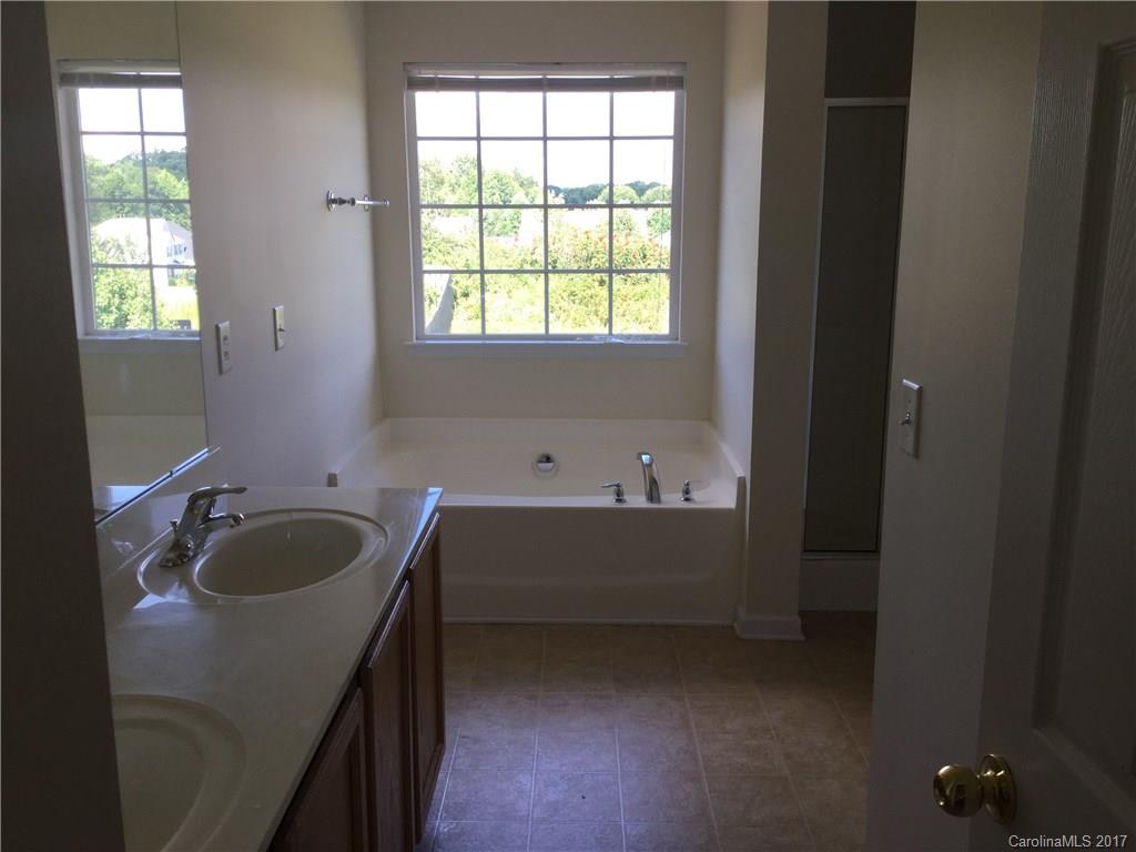 6304 Trotters Ridge Road Charlotte, NC 28227 - Photo 7 of 9 a bathroom with a granite countertop sink and a bathtub