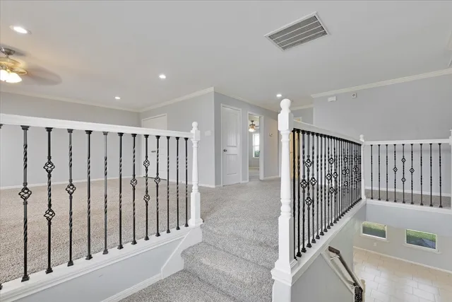 a view of a hallway with white walls and stairs