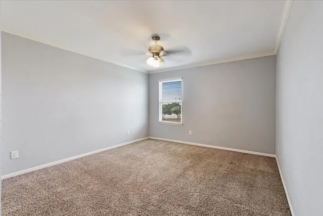 an empty room with windows and ceiling fan