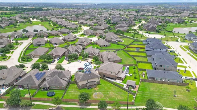 an aerial view of residential houses with outdoor space and parking