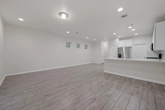 a view of an empty room with wooden floor and closet