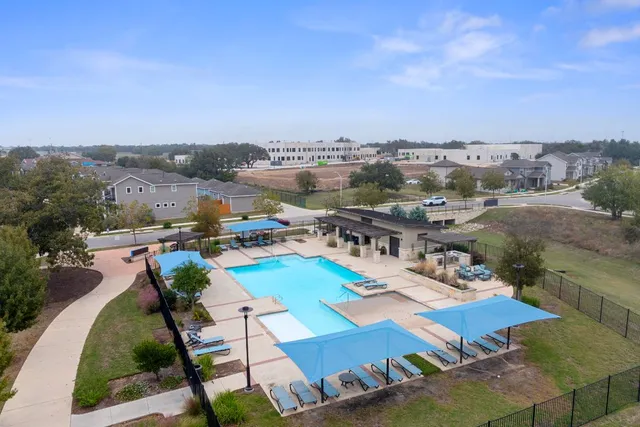 an aerial view of multiple houses with a big yard