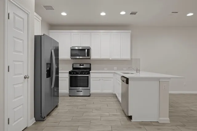 a view of kitchen with wooden floor and electronic appliances