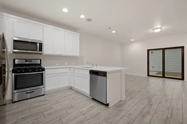 a kitchen with stainless steel appliances a refrigerator and a stove top oven