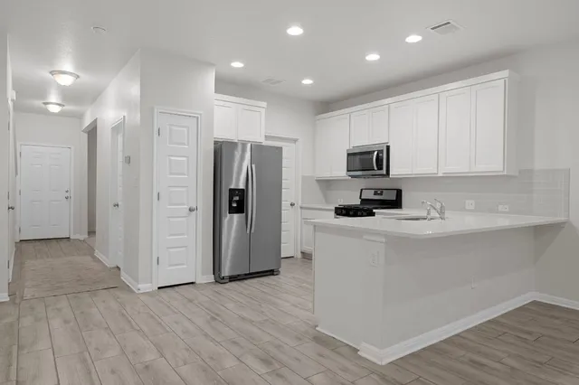 a kitchen with wooden floors and stainless steel appliances