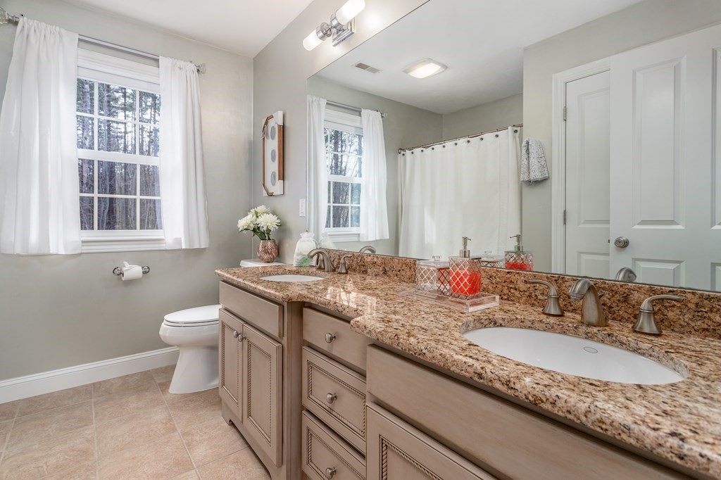 298 Harvard Road Bolton, MA 01740 - Photo 30 of 42 a bathroom with a granite countertop double vanity sink toilet and a mirror