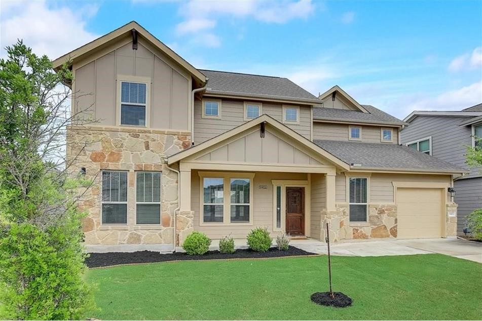 a front view of a house with a garden and yard