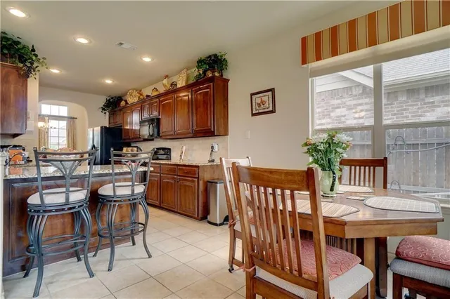 a kitchen with a dining table chairs and a dining table