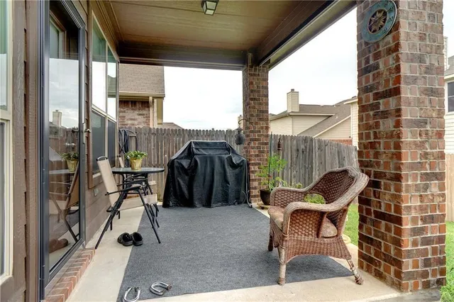 a patio with glass top table and chairs