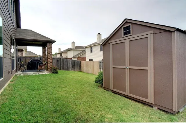 a view of backyard of house and wooden deck