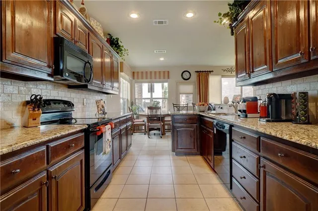 a kitchen with stainless steel appliances granite countertop a sink stove and cabinets