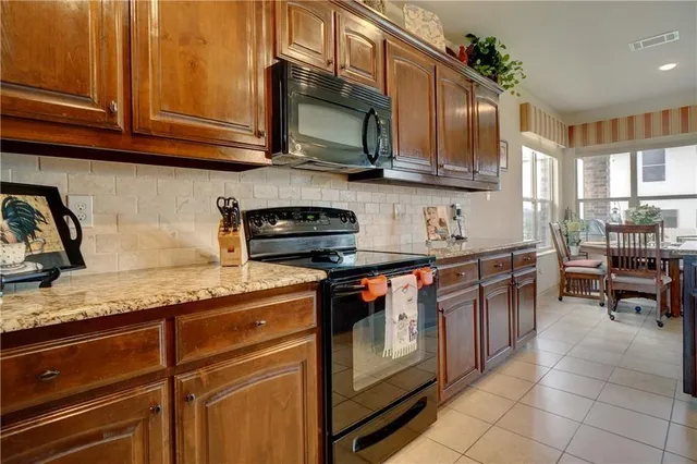 a kitchen with stainless steel appliances granite countertop a stove a sink and a microwave