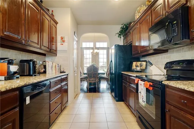 a kitchen with stainless steel appliances granite countertop a stove sink and cabinets