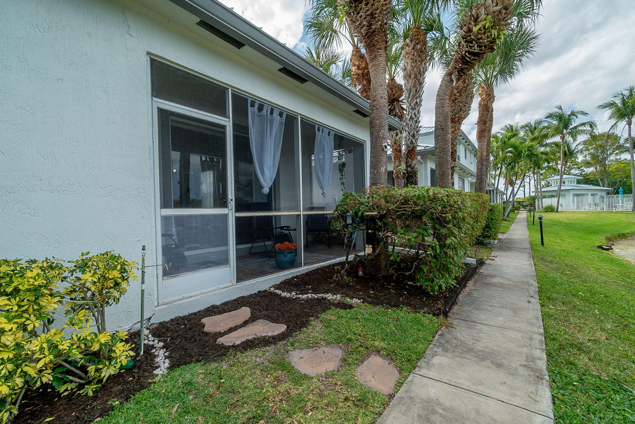 115 Coconut Key Lane Delray Beach, FL 33484 - Photo 20 of 23 a view of a backyard with potted plants and a large tree