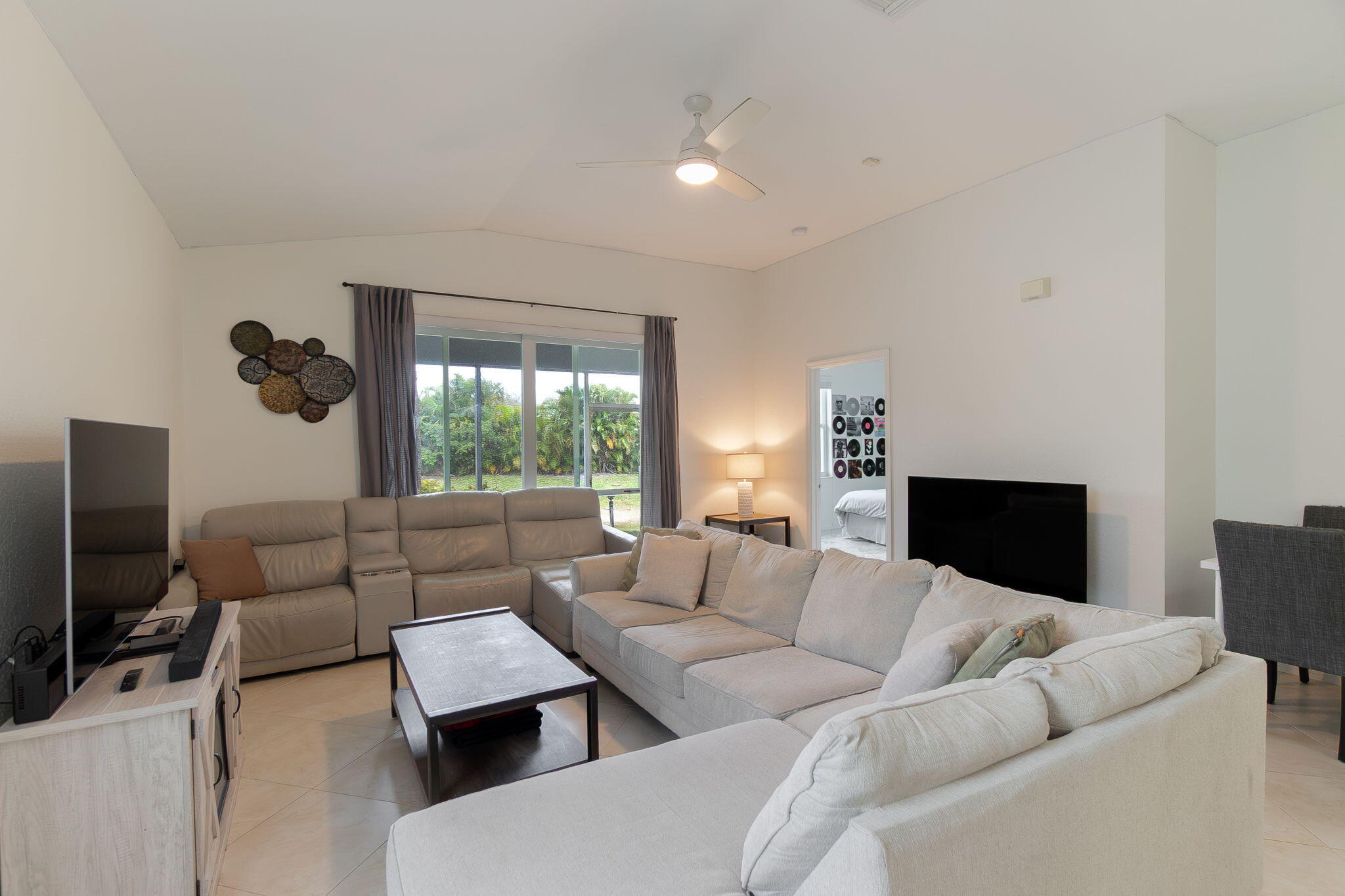 115 Coconut Key Lane Delray Beach, FL 33484 - Photo 3 of 23 a living room with furniture a flat screen tv and a large window