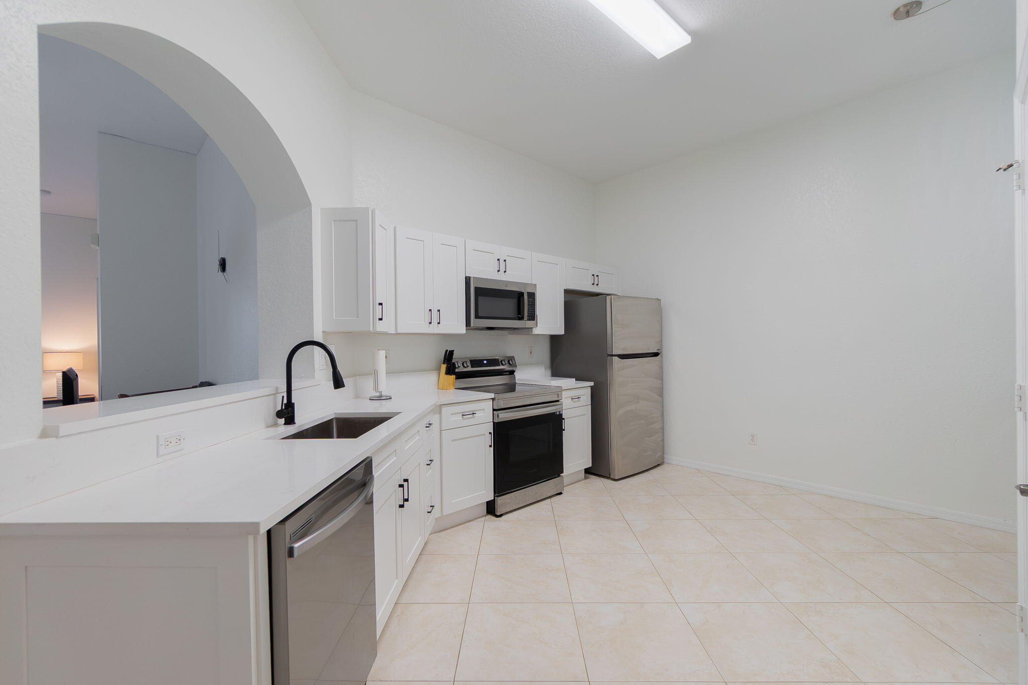 115 Coconut Key Lane Delray Beach, FL 33484 - Photo 7 of 23 a kitchen with stainless steel appliances a sink stove and refrigerator