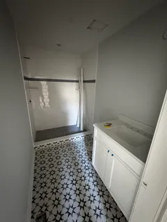 a bathroom with a granite countertop sink and a shower