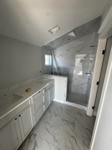a view of a bathroom with double vanity sink and mirror