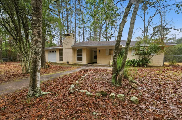an empty room with wooden floor chandelier and windows