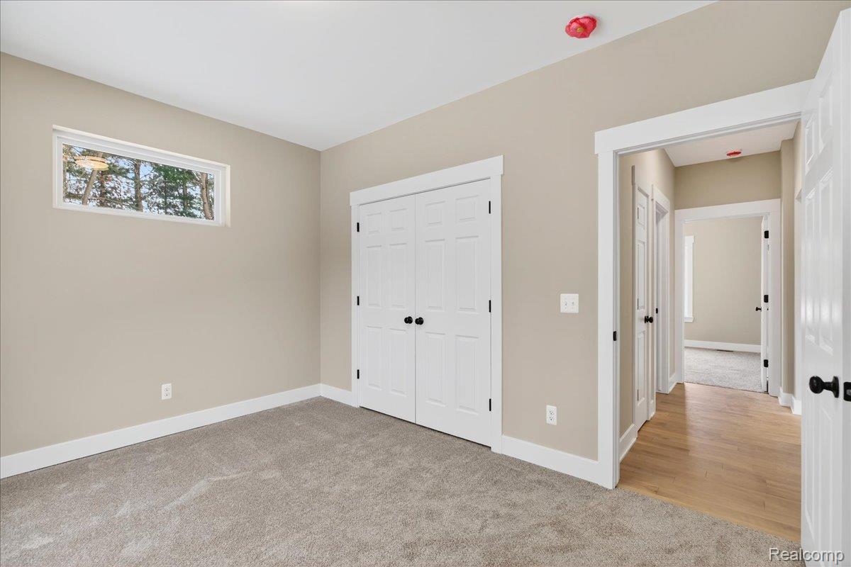 4050 Metamora Ridge Road Metamora, MI 48455 - Photo 54 of 65 Unfurnished bedroom with light colored carpet and a closet