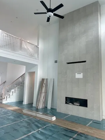 a view of a livingroom with wooden floor and a ceiling fan