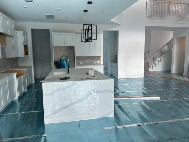 a kitchen with kitchen island granite countertop a sink a counter top space and cabinets