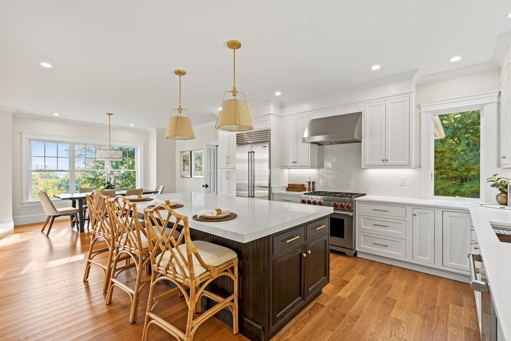 83 Wheeler Road Stow, MA 01775 - Photo 10 of 42 a open kitchen with stainless steel appliances granite countertop a stove top oven a sink dishwasher and white cabinets with wooden floor