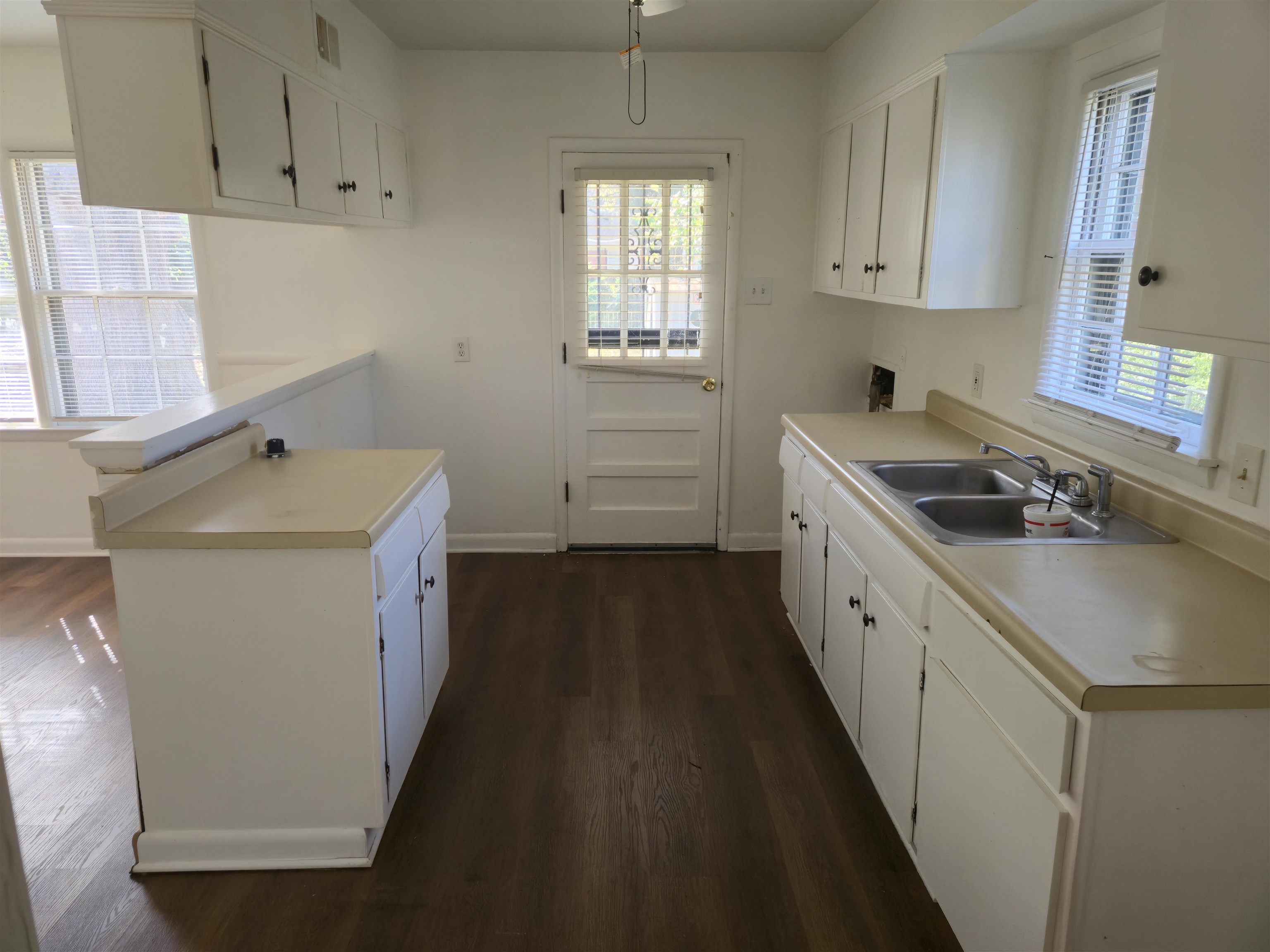 1517 Delmont Road Memphis, TN 38117 - Photo 4 of 9 Kitchen with light countertops, dark wood finished floors, white cabinetry, and a peninsula