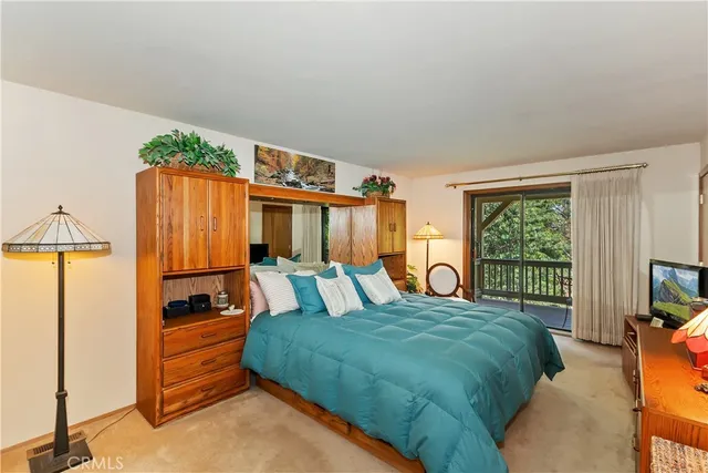 a bedroom with a bed and large windows