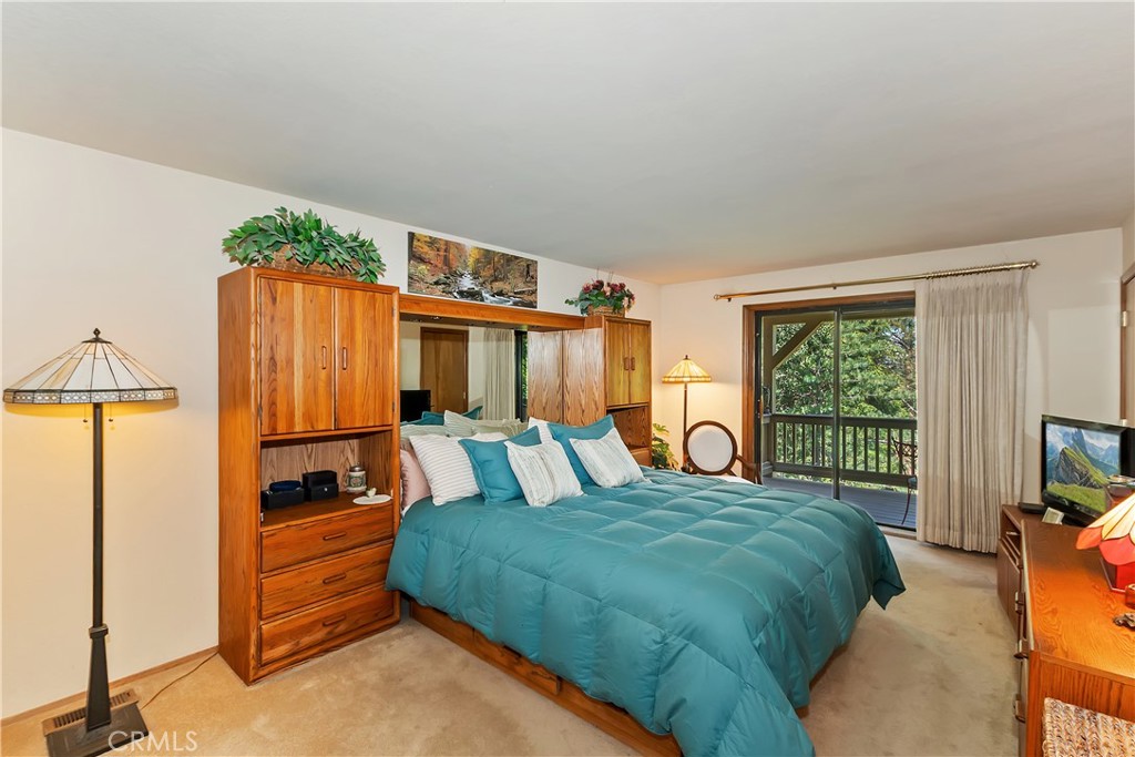 1100 Arbula Drive Crestline, CA 92325 - Photo 17 of 50 a bedroom with a bed and a chandelier