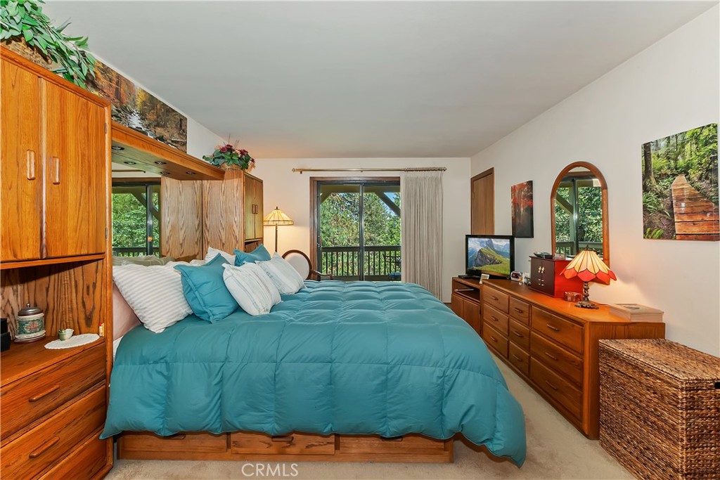 1100 Arbula Drive Crestline, CA 92325 - Photo 18 of 50 a bedroom with a bed and large windows