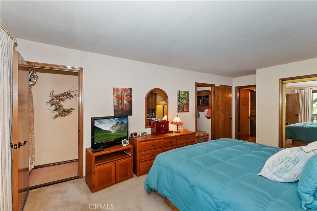 1100 Arbula Drive Crestline, CA 92325 - Photo 19 of 50 a bedroom with a bed and a dresser with mirror
