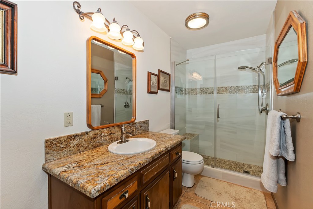 1100 Arbula Drive Crestline, CA 92325 - Photo 20 of 50 a bathroom with a granite countertop sink toilet and shower
