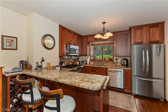 a kitchen with a refrigerator a stove a sink and a dining table with chairs