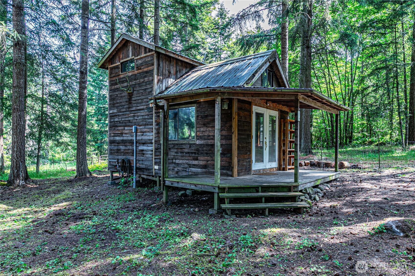 16728 Longmire Road Southeast Yelm, WA 98597 - Photo 17 of 38 a view of a wooden house with a yard and large trees