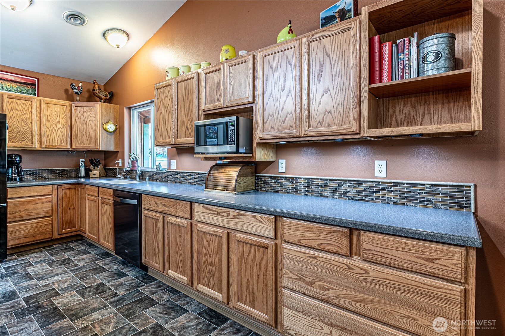 16728 Longmire Road Southeast Yelm, WA 98597 - Photo 21 of 38 a kitchen with granite countertop a stove a sink and a microwave