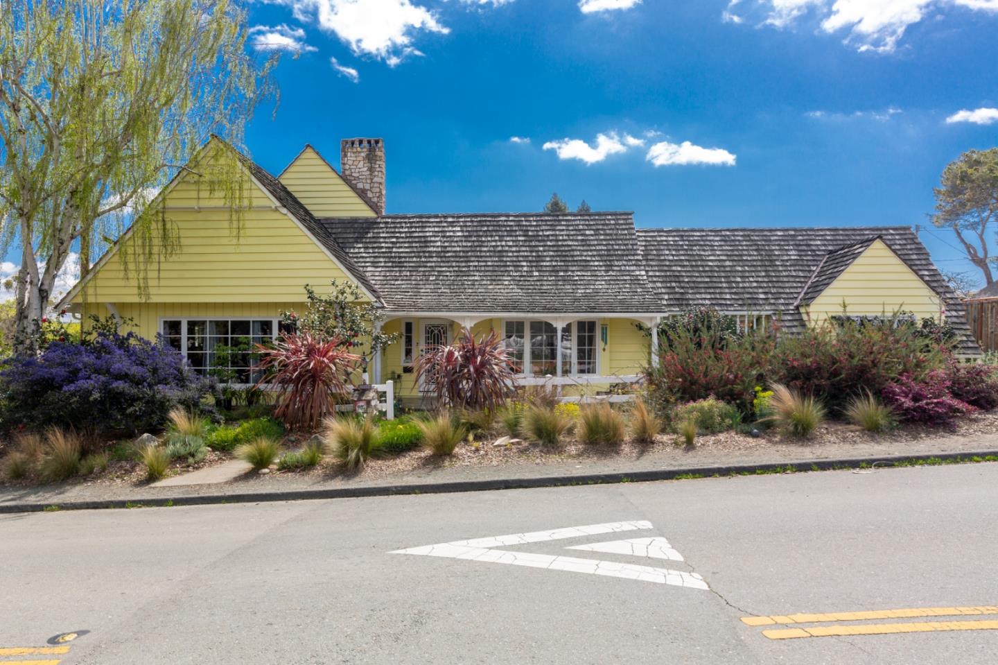 a front view of a house with a yard and potted plants