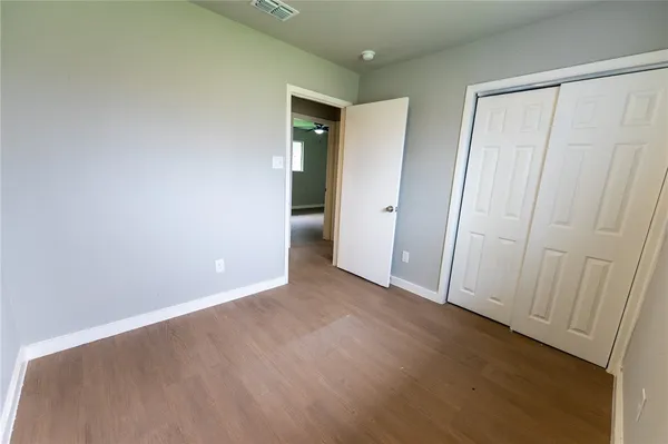 a view of an empty room with wooden floor