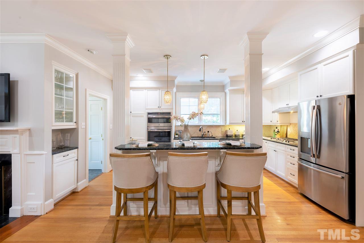 1110 Harvey Street Raleigh, NC 27608 - Photo 5 of 30 The kitchen has been recently updated and includes elegant lighting features, marble countertops and island with room for extra seating.