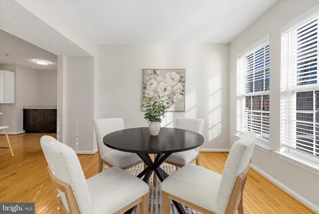 a view of a dining room with furniture a rug and wooden floor