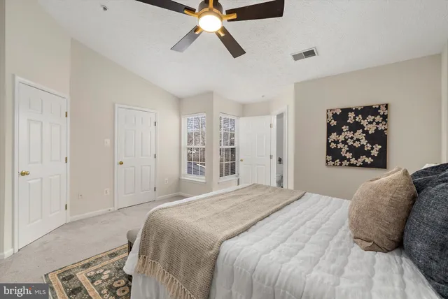a bedroom with a bed and a ceiling fan