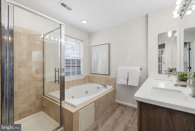 a bathroom with a tub sink and mirror
