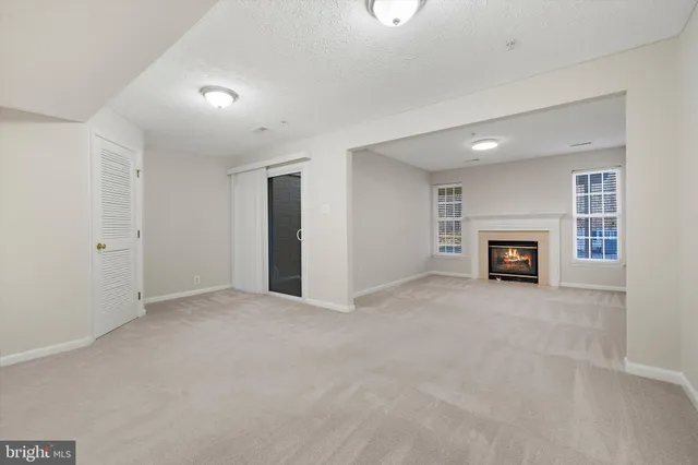 an empty room with fireplace and a window