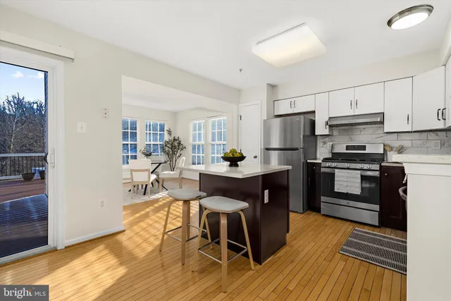 a kitchen with granite countertop wooden floors and white cabinets