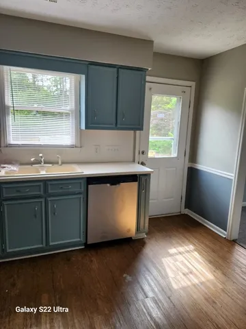 a kitchen with a sink window and cabinets