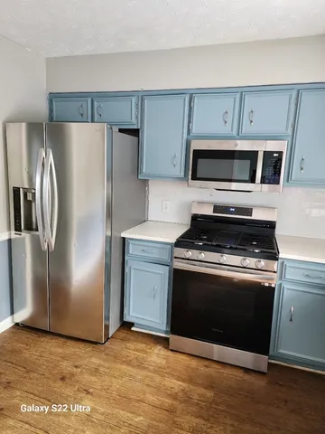 a kitchen with granite countertop a stainless steel stove and refrigerator