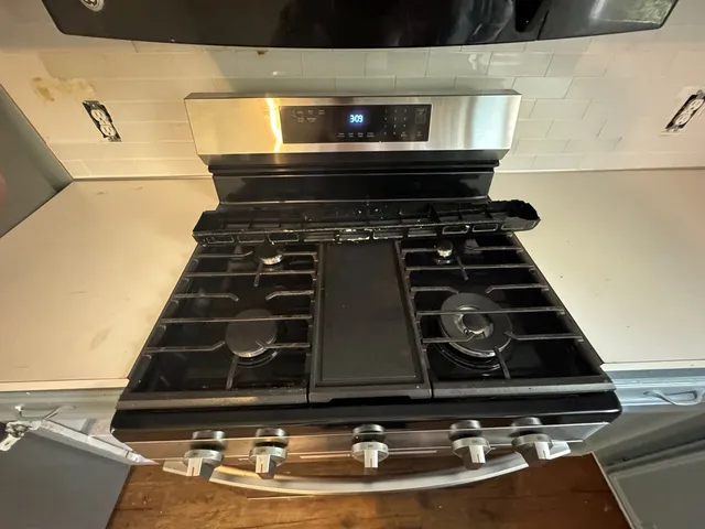 a stove top oven sitting inside of a kitchen