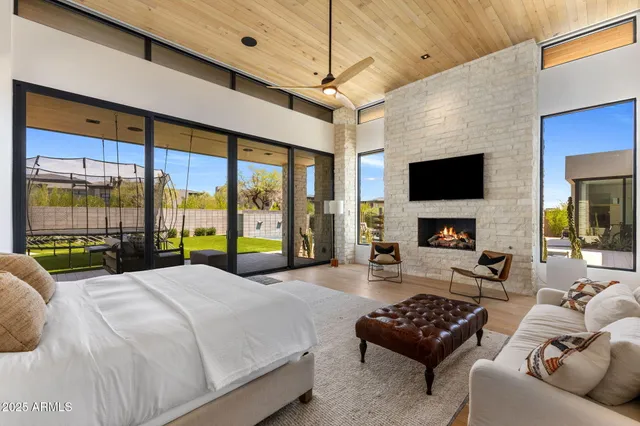 a bedroom with a bed a couch and a flat tv screen