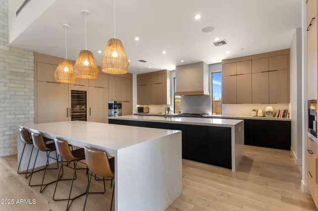 a kitchen with kitchen island granite countertop a sink counter and chairs